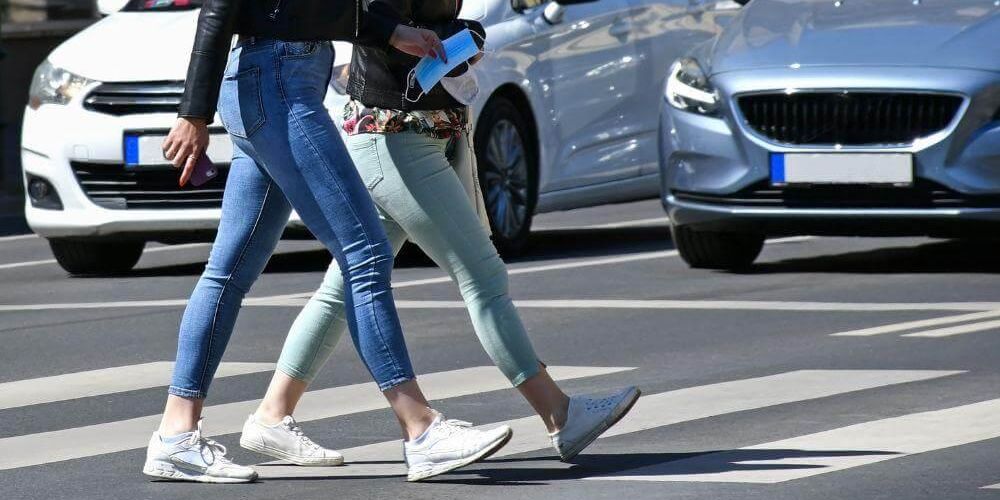 Two women crossing street, relevant to