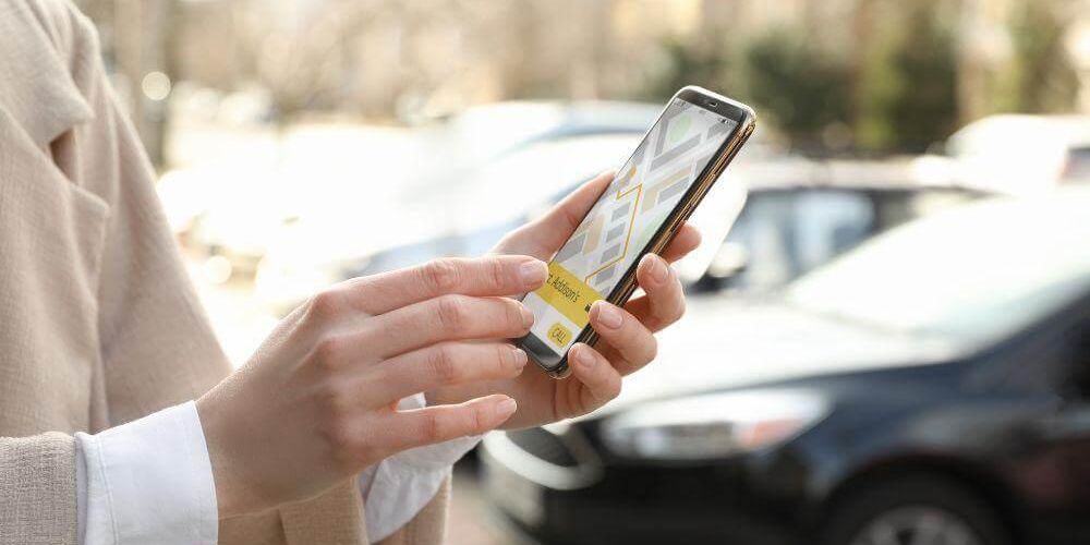 Woman holding smartphone, likely a client reviewing a rides