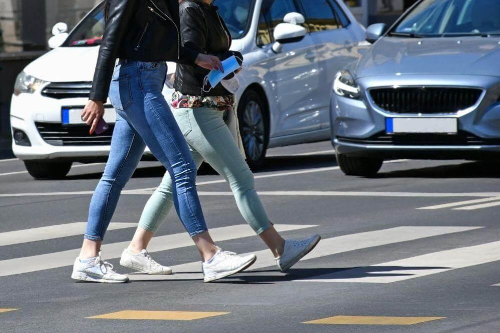 Two women crossing street, relevant to